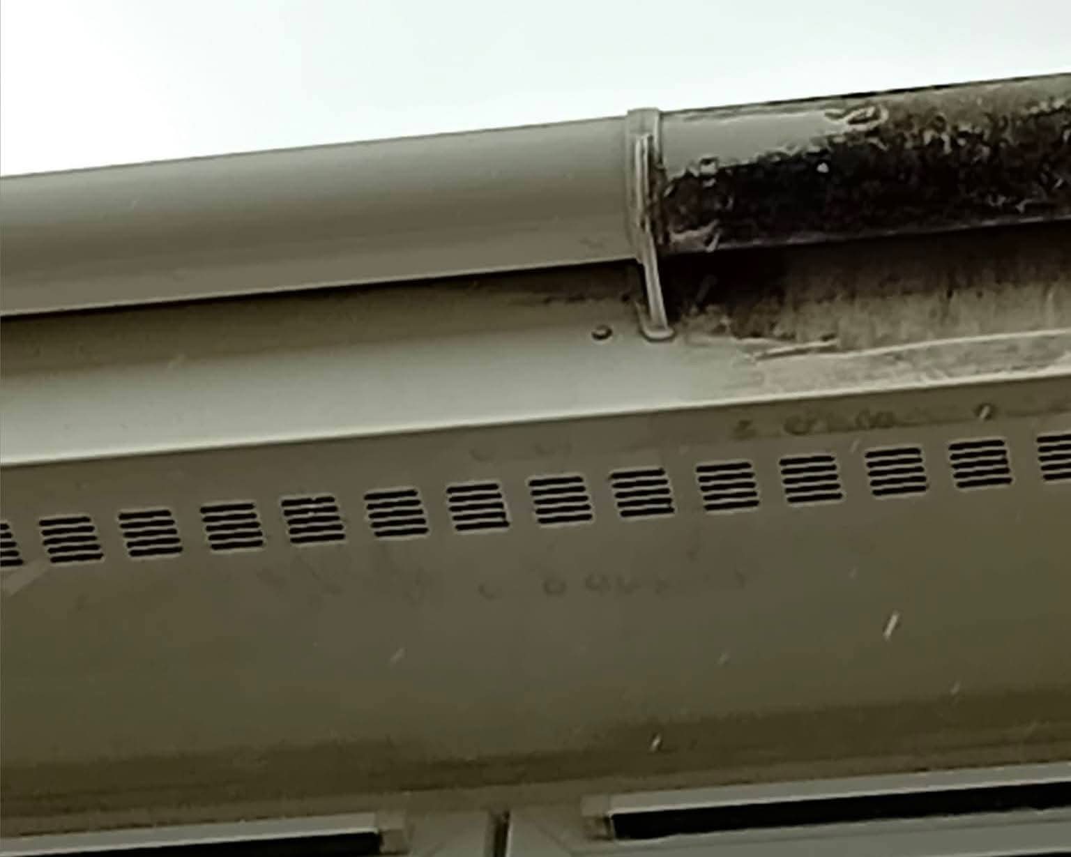 Close-up of a dirty soffit vent strip before fascia and soffit cleaning