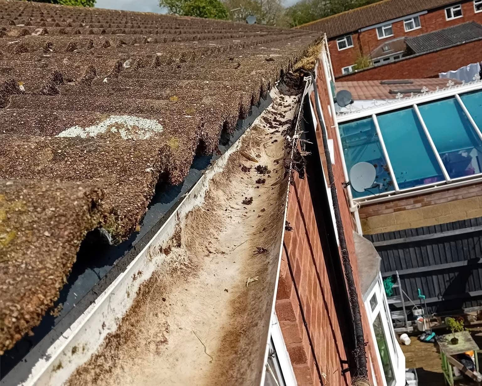 Mud- and silt-packed gutter run before wet-vac emptying — South Hampshire semi